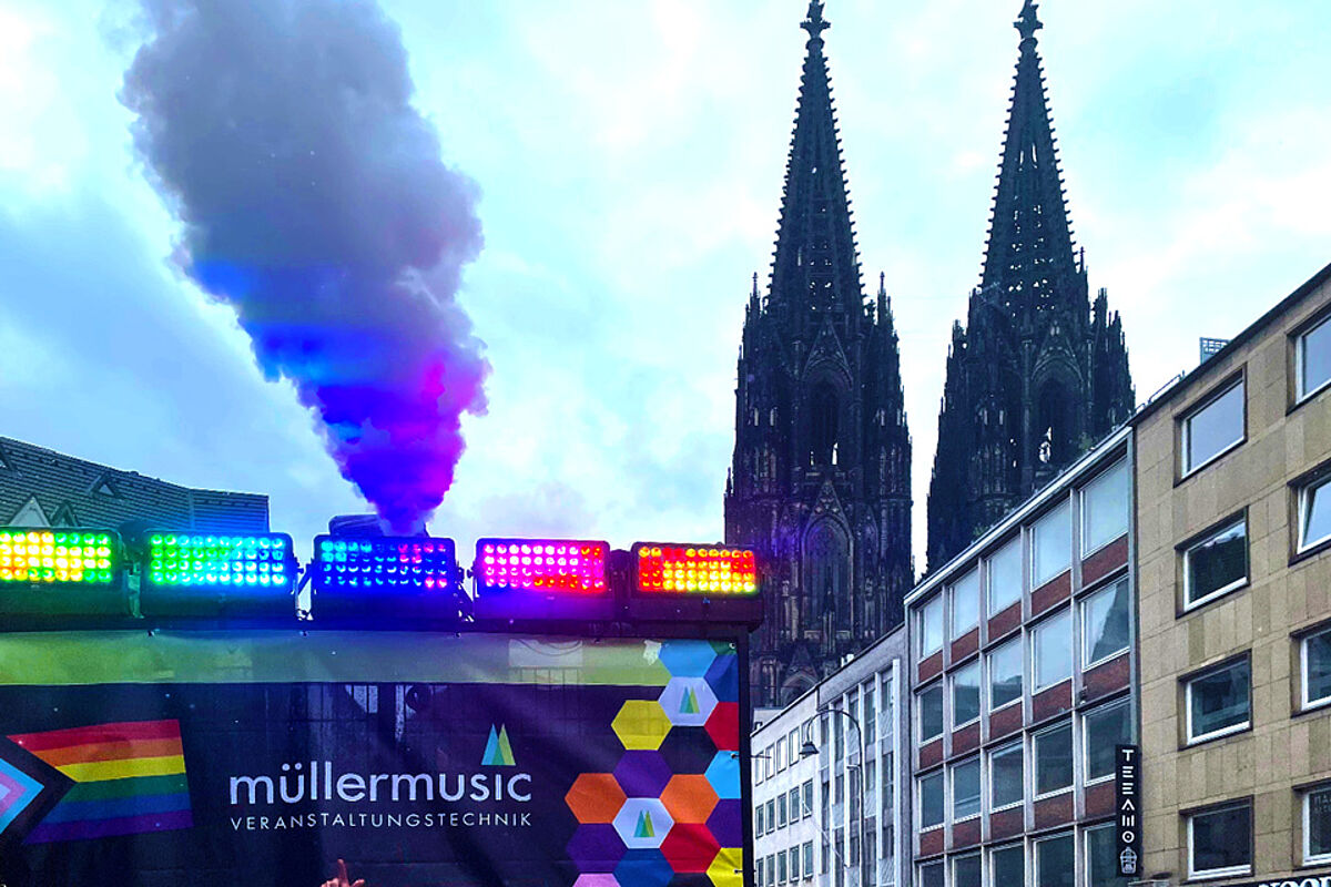 Ein schöner Blick auf den Kölner Dom. Im Vordergrund sieht man den müllermusic-Truck mit seinen vielen bunten LED-Lichtern von hinten.
